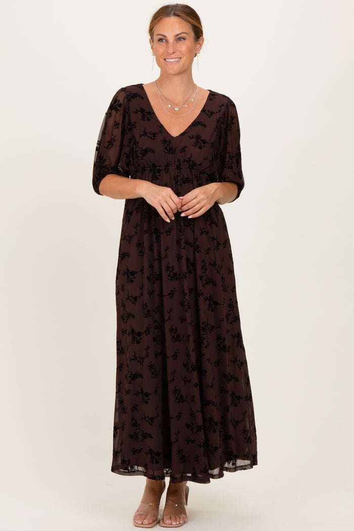 woman wearing a brown maxi dress with a floral print and short puff sleeves