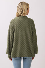 woman wearing an olive green checkered oversized sweater, viewed from the back, paired with light blue jeans