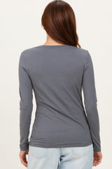 woman wearing a gray long sleeve top viewed from the back, styled with light blue jeans