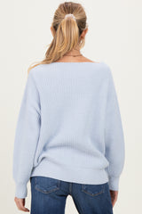 woman wearing a light blue oversized maternity sweater with balloon sleeves, viewed from the back
