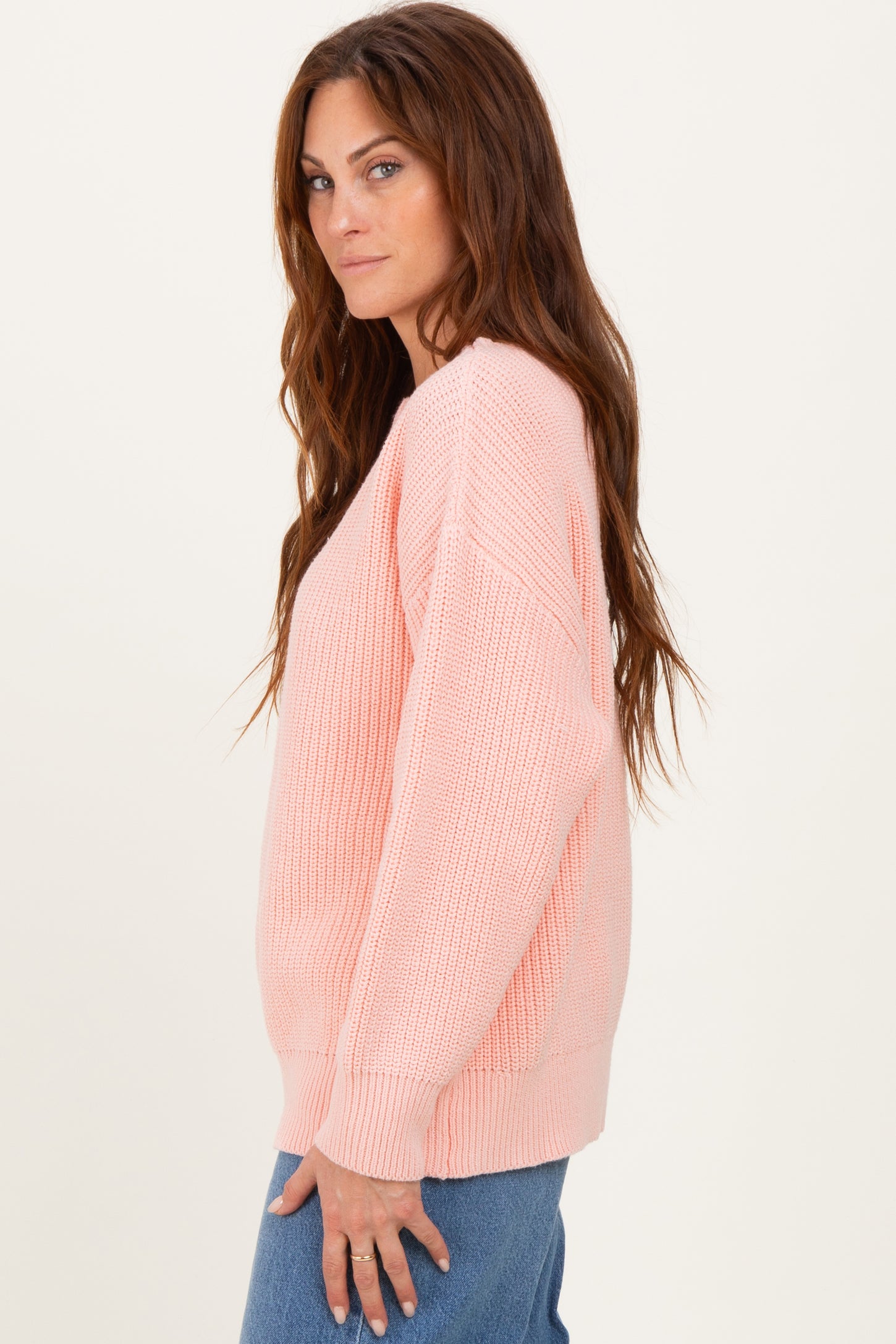 woman wearing a soft pink oversized knit sweater with long sleeves and a relaxed fit