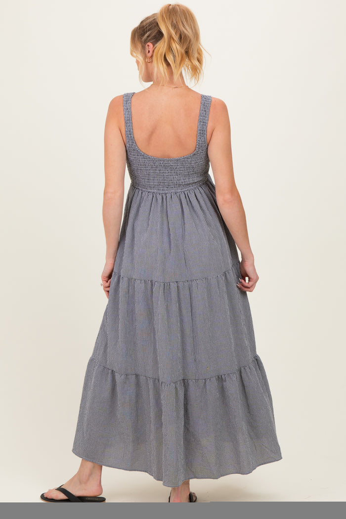 woman wearing a navy and white striped maternity maxi dress with a smocked bodice and tiered hem