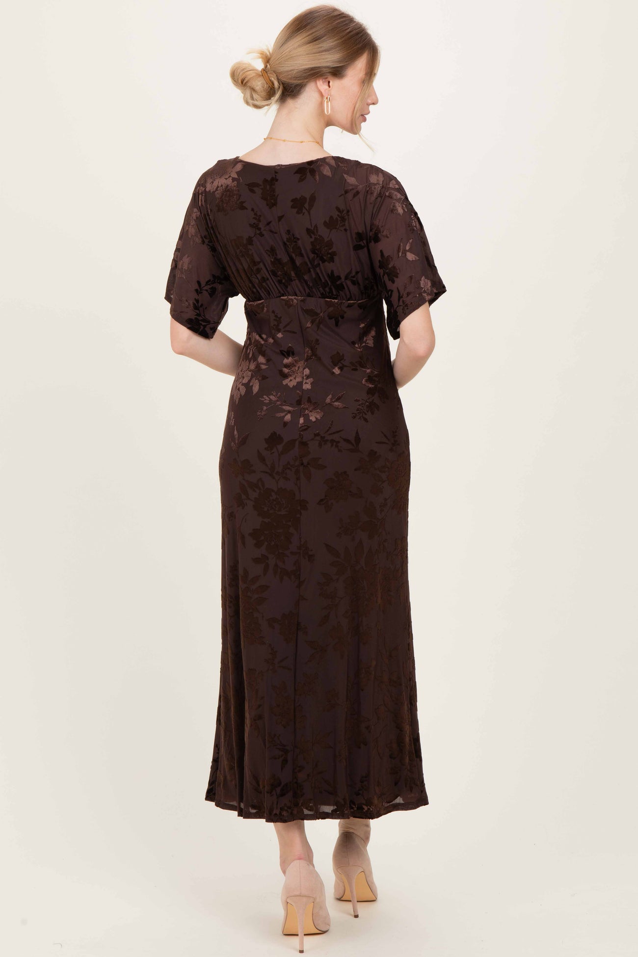 woman wearing a brown floral print maxi dress with short sleeves, showing the back view