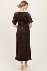 woman wearing a brown floral print maxi dress with short sleeves, showing the back view