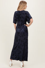 woman wearing a navy blue floral maxi dress with short sleeves, seen from the back