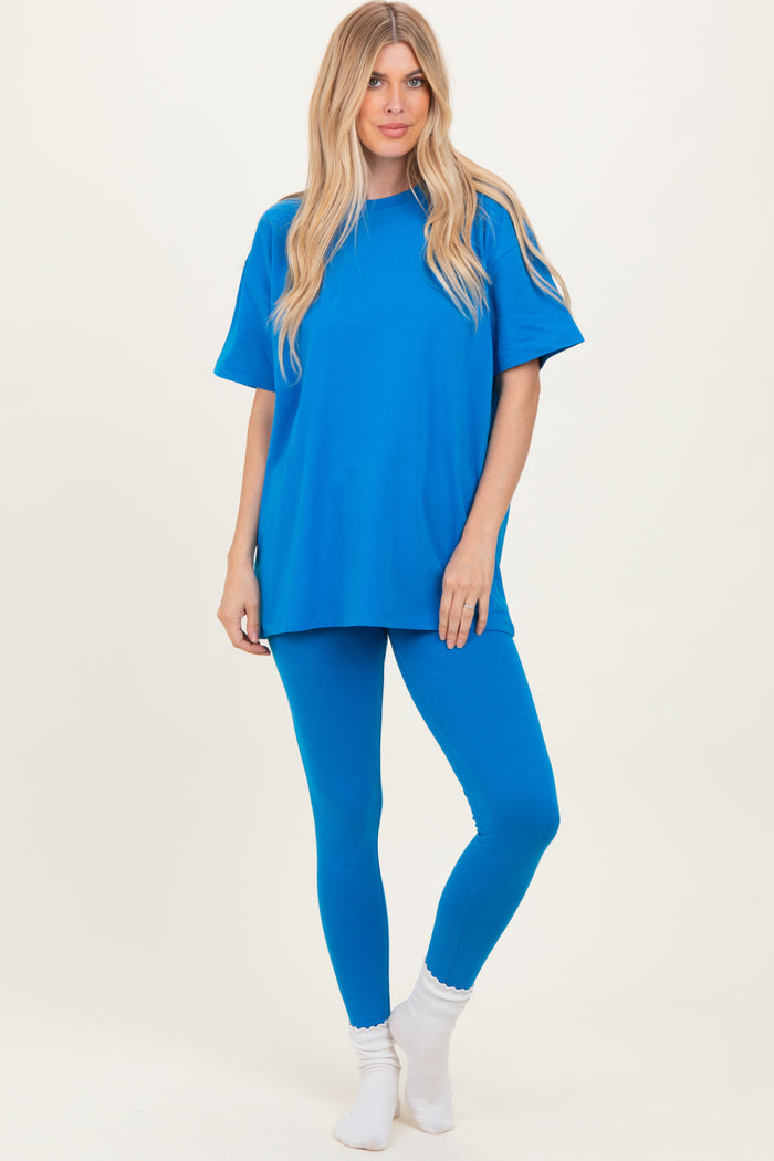 woman wearing a bright blue oversized t-shirt and matching leggings, standing with a relaxed pose