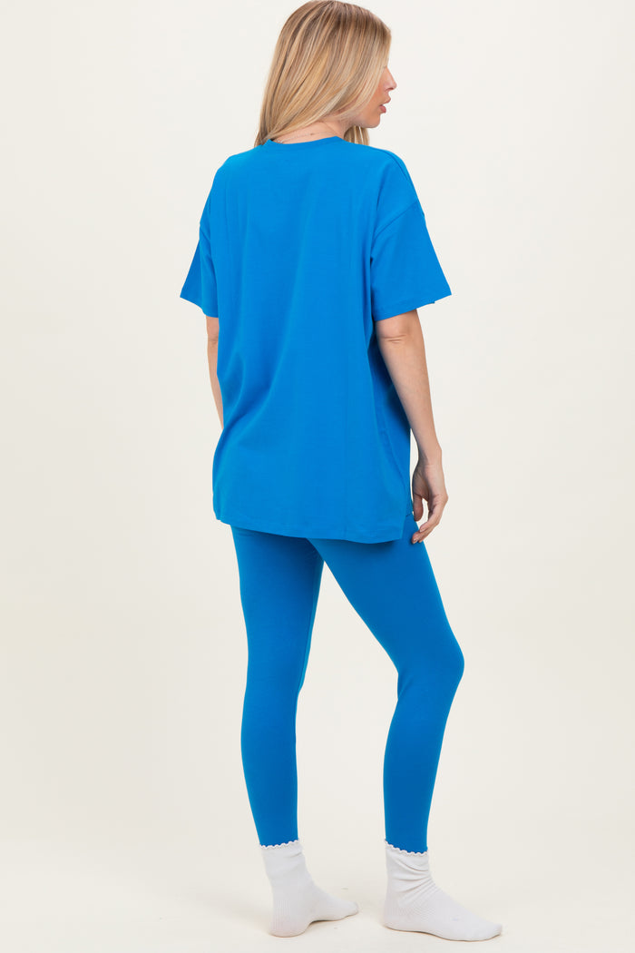 woman wearing a bright blue oversized t-shirt and matching blue leggings, with white ankle socks visible