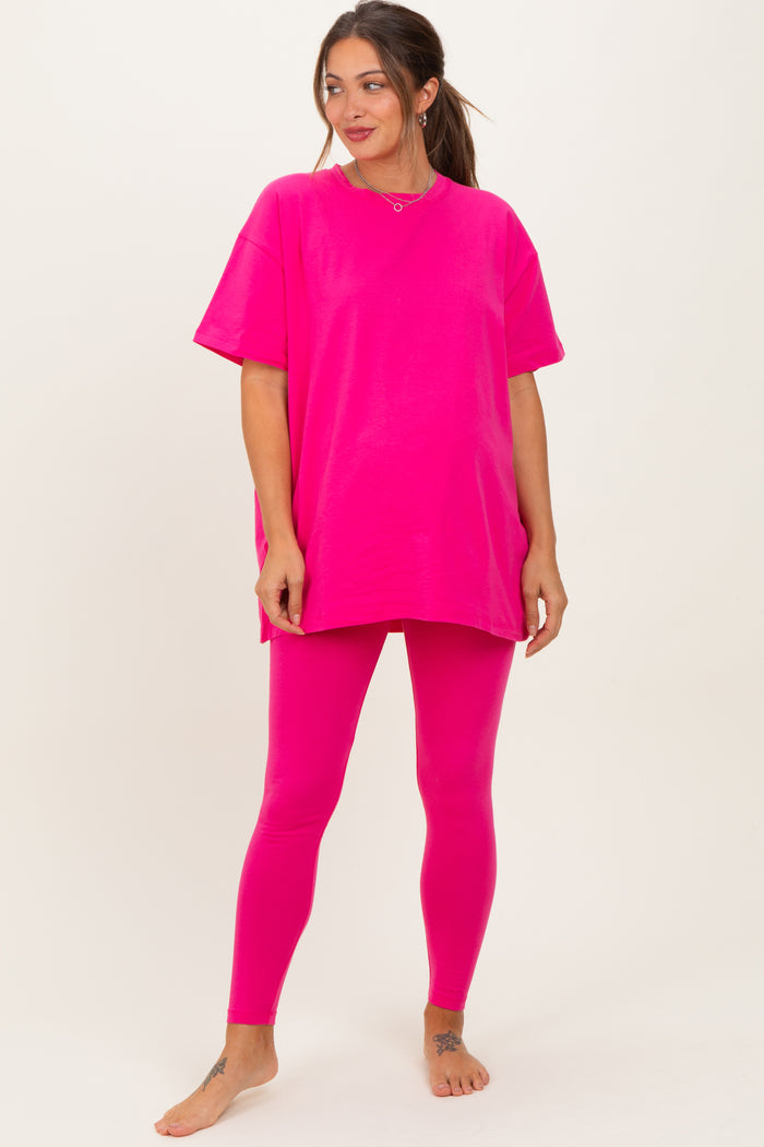woman wearing a bright pink oversized maternity t-shirt and matching leggings, showcasing her baby bump