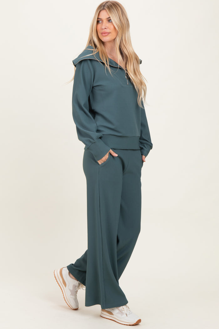 woman wearing a teal ribbed hoodie and matching wide-leg pants, styled with white sneakers