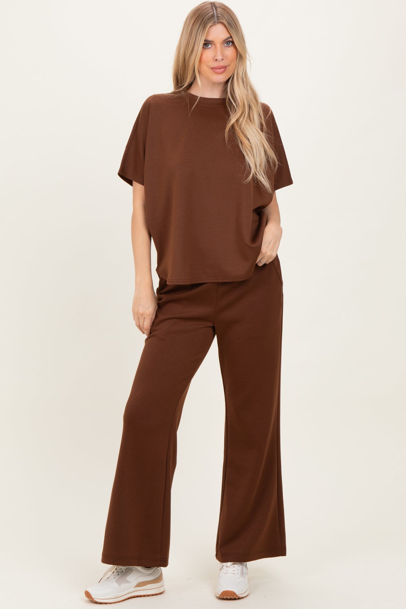 woman wearing a brown oversized t-shirt and matching wide-leg pants, styled with white sneakers