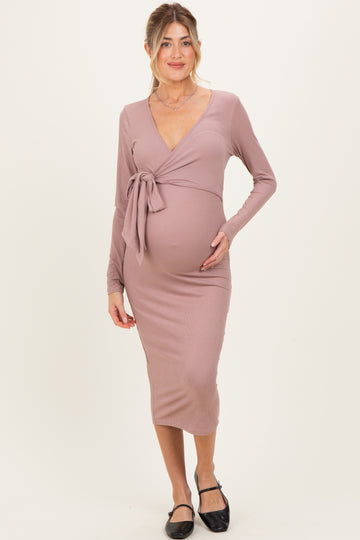 woman wearing a mauve long sleeve wrap maternity dress with a tie detail and visible baby bump