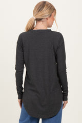 woman wearing a dark gray long sleeve top with a curved hem and relaxed fit, seen from the back