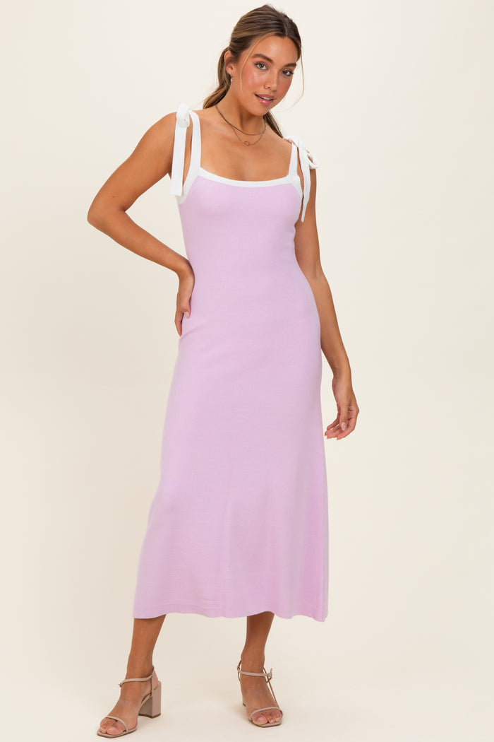 woman wearing a lilac spaghetti strap midi dress with white tie straps and a fitted silhouette