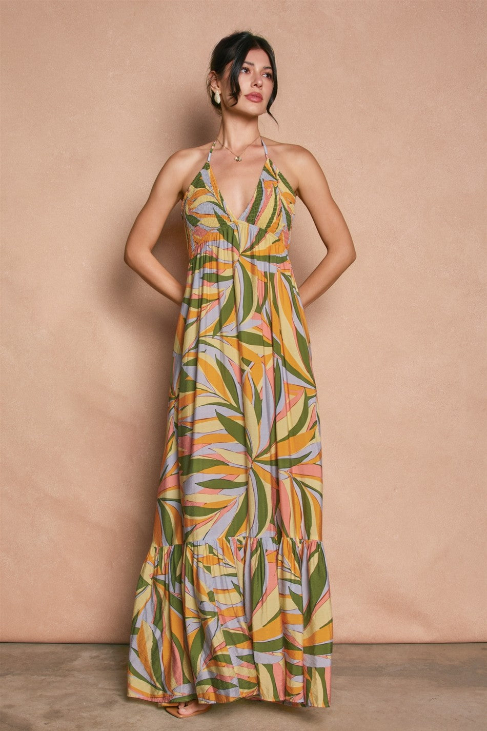 woman wearing a colorful floral maxi dress with a halter neck and tiered hem