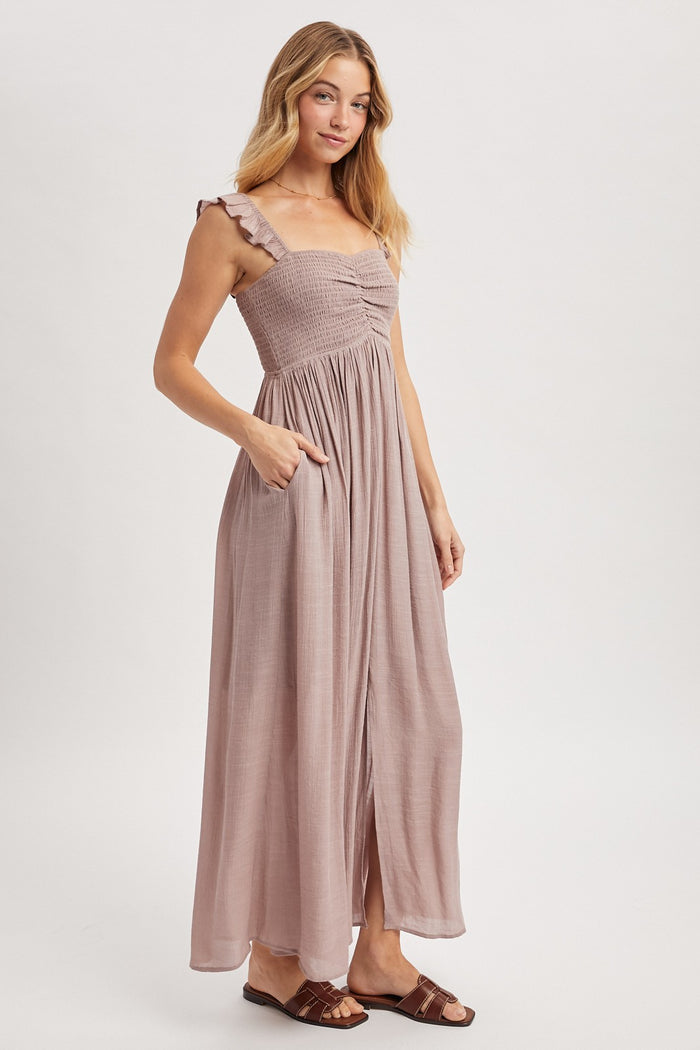 woman wearing a mauve maxi dress with ruffle straps, smocked bodice, and pockets