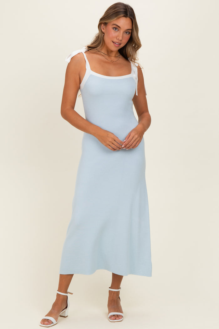 woman wearing a light blue ribbed midi dress with white tie straps and heeled sandals