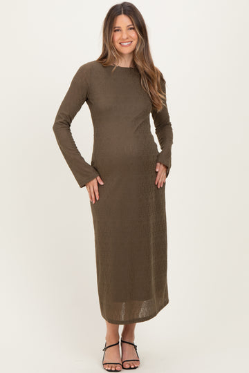 woman wearing a dark olive long sleeve maternity dress with a fitted silhouette and a visible baby bump