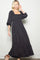 woman wearing a black floral maxi dress with a square neckline and puff sleeves, standing elegantly