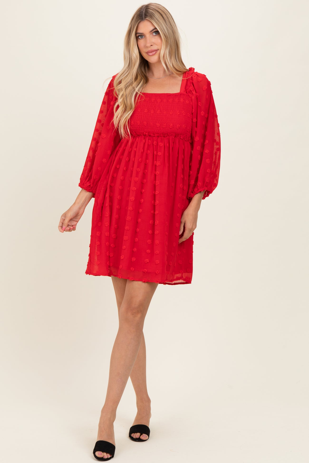 woman wearing a red puff sleeve mini dress with a smocked bodice and textured dots