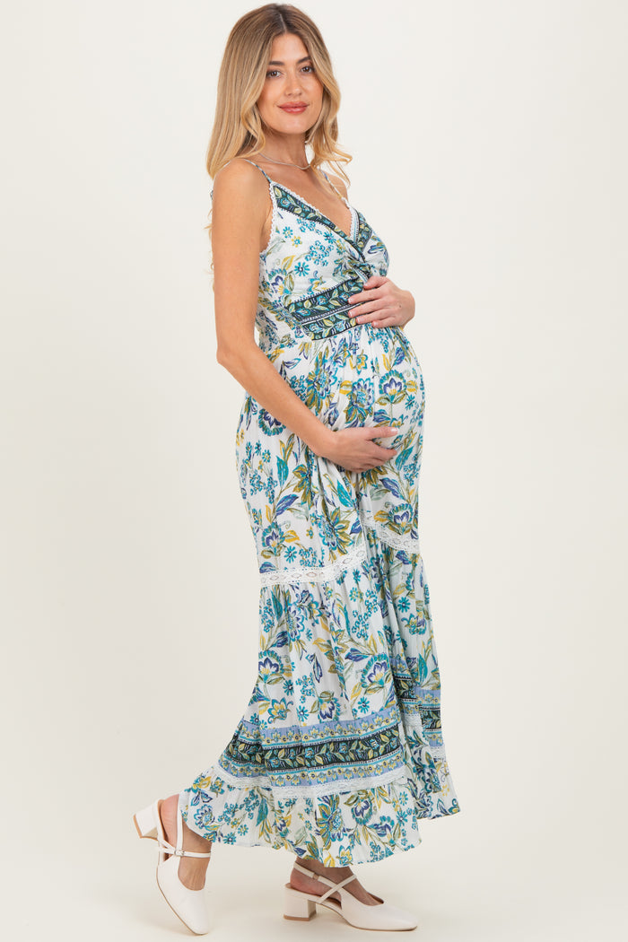 woman wearing a floral print maternity maxi dress and holding her baby bump