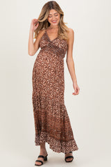 woman wearing a brown patterned maternity maxi dress with a halter neckline and a baby bump visible