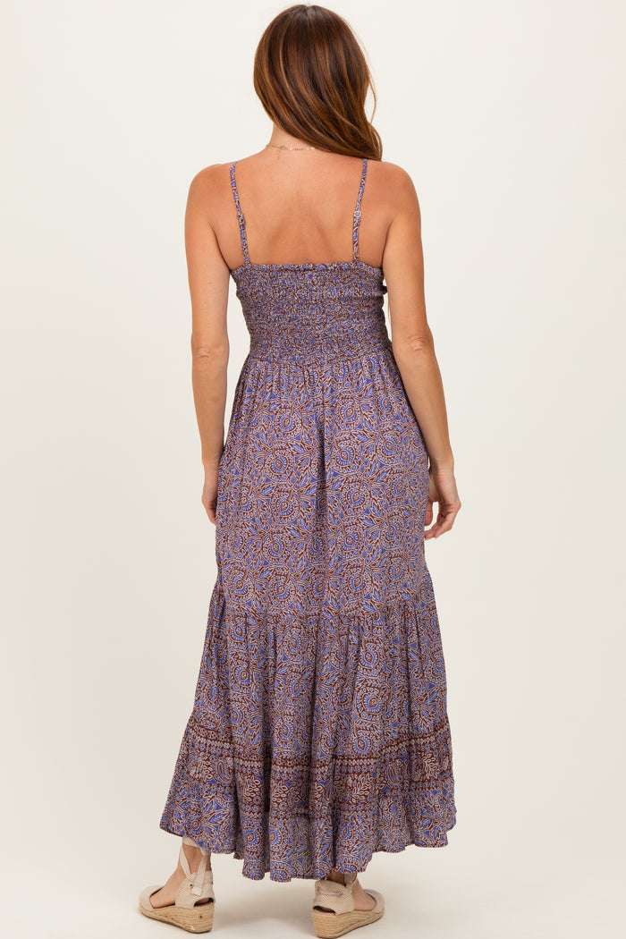 woman wearing a purple patterned maxi dress with smocked bodice and tiered skirt, viewed from the back
