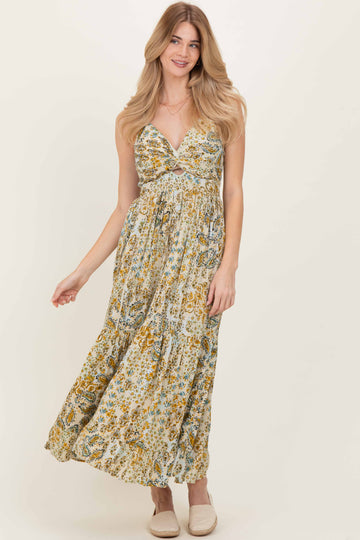 woman wearing a floral print maxi dress with a deep v-neck and braided straps, posing with a smile