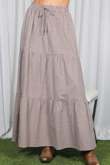 woman wearing a brown and white gingham tiered maxi skirt with an elastic waistband and drawstring detail