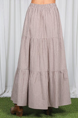woman wearing a brown and white checked tiered maxi skirt with an elastic waistband