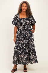 plus size woman wearing a black floral maxi dress with a square neckline and puff sleeves, standing with hands in pockets