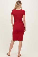 woman wearing a fitted red midi dress with short sleeves and a back slit, showing the back view