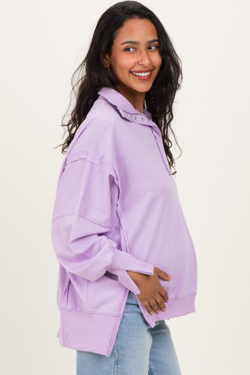 woman wearing a lavender oversized maternity sweatshirt with a collar and visible baby bump