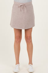 woman wearing a light pink maternity skort with drawstring waist and side pockets