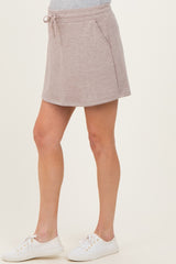 woman wearing a light brown maternity skort with side pockets and a drawstring waistband