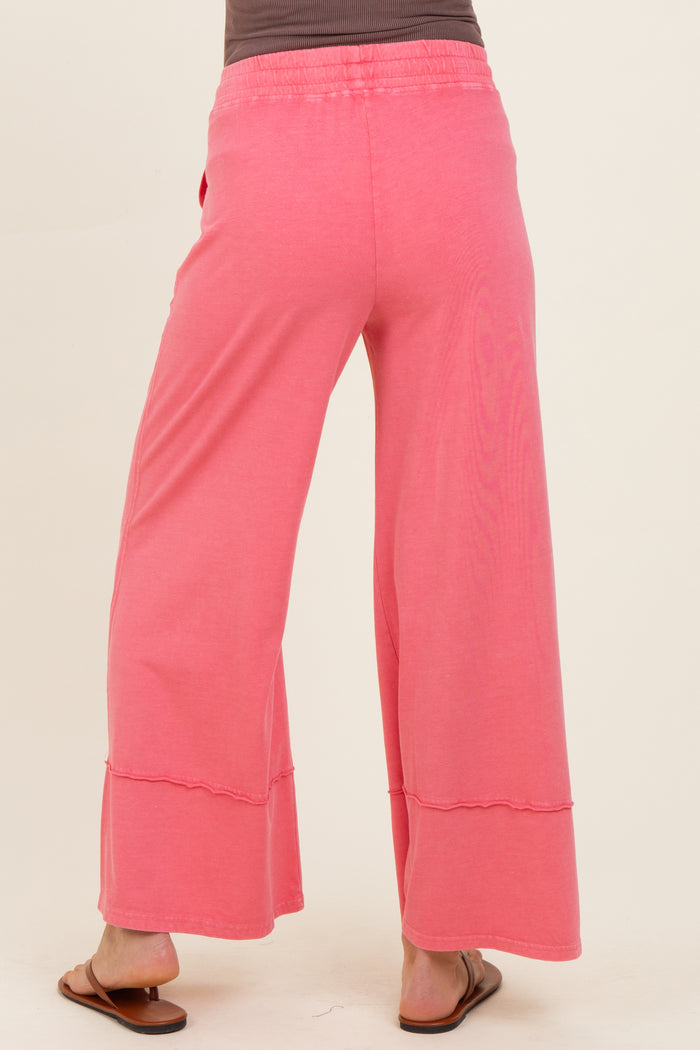 woman wearing pink maternity wide-leg pants, shown from the back, featuring a relaxed fit and comfortable waistband