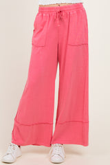 woman wearing pink wide-leg pants with front pockets and a drawstring waist