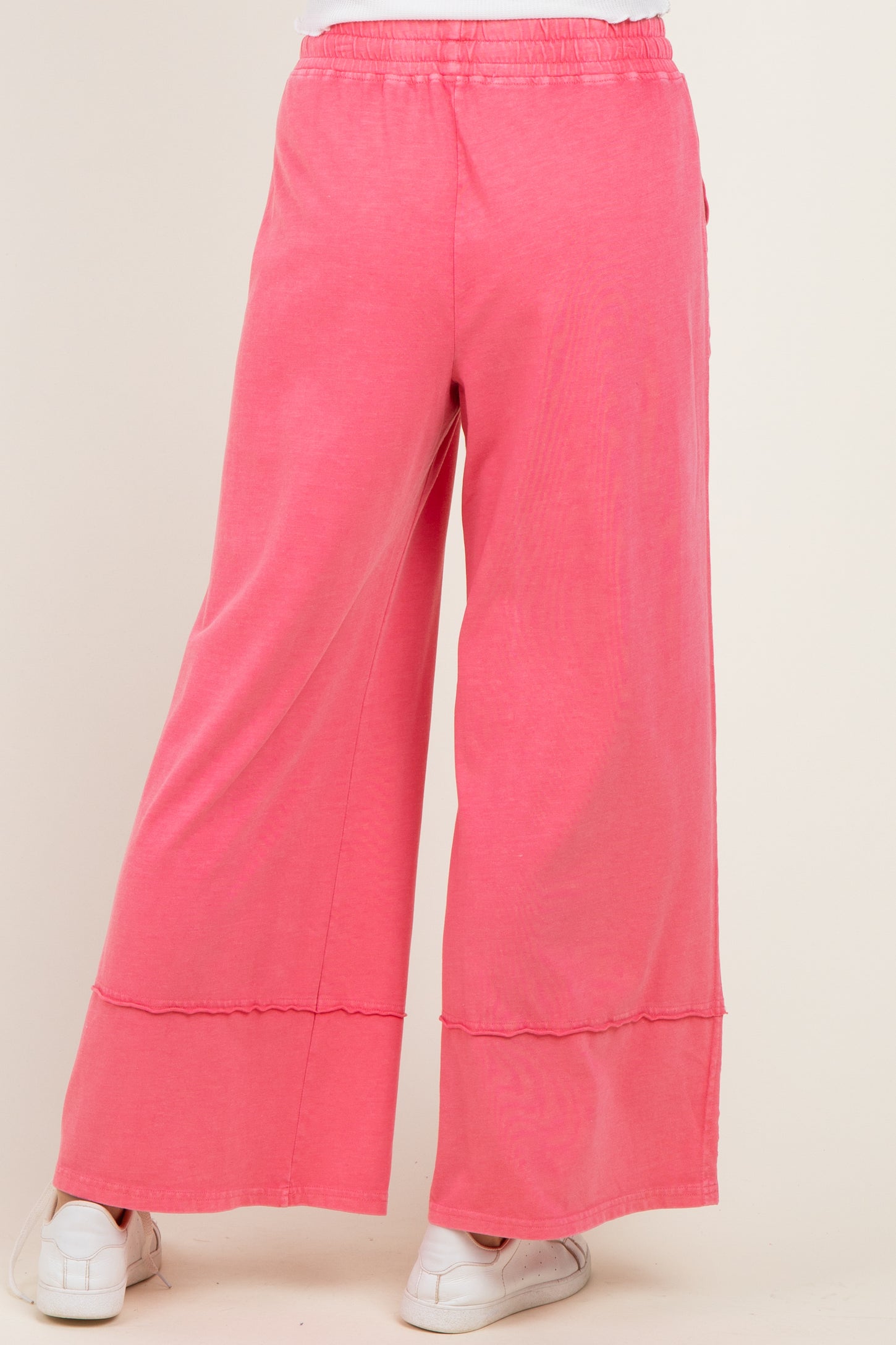 woman wearing pink wide leg pants with a relaxed fit and an elastic waistband, shown from the back