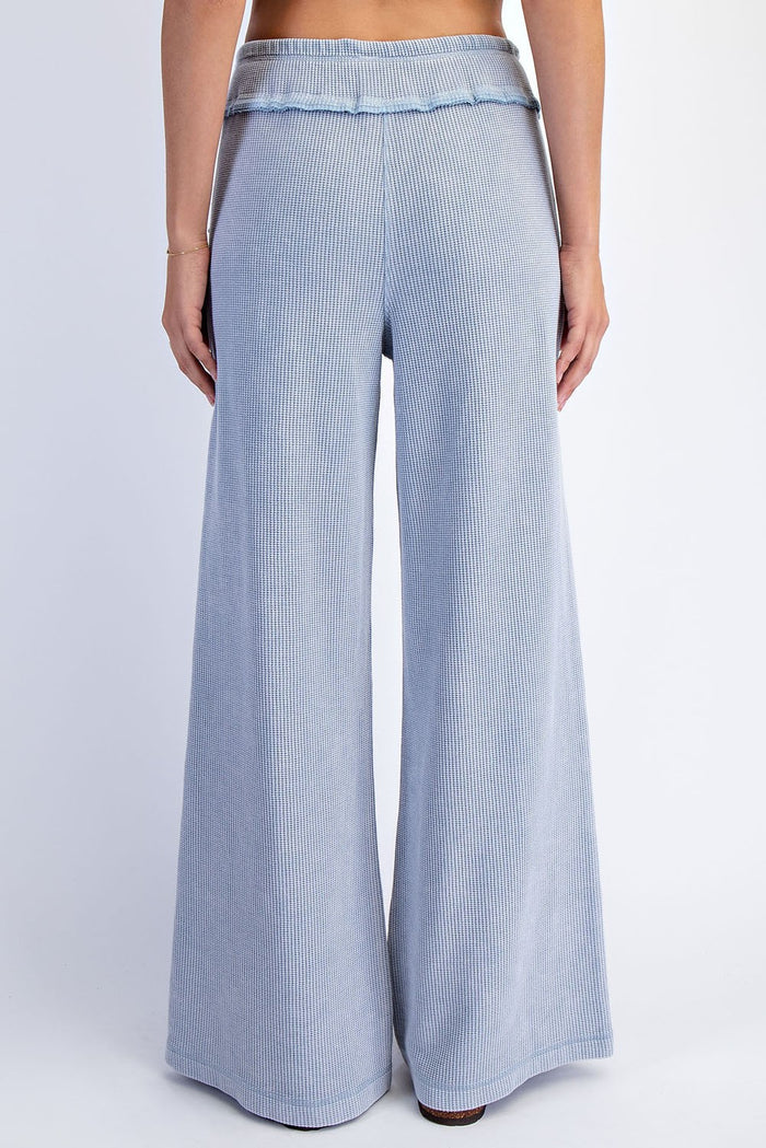 woman wearing light blue ribbed wide-leg pants, showing the back view with a flowy fit