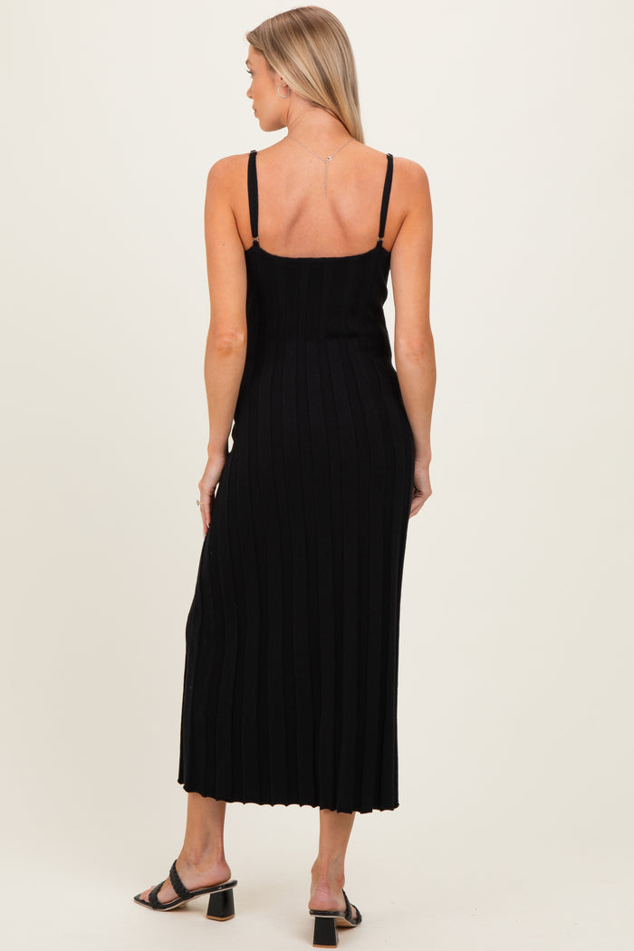 woman wearing a fitted black ribbed maternity dress with adjustable straps, showing a subtle back design