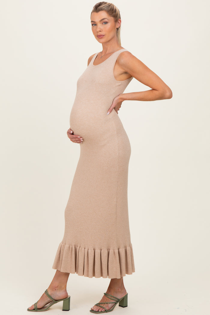 woman wearing a beige ribbed maternity dress with a flared hem and holding her baby bump