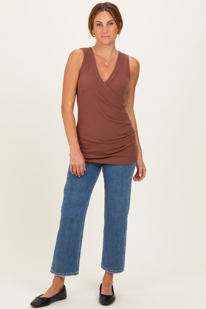 woman wearing a brown sleeveless wrap top paired with blue wide-leg jeans and black flats