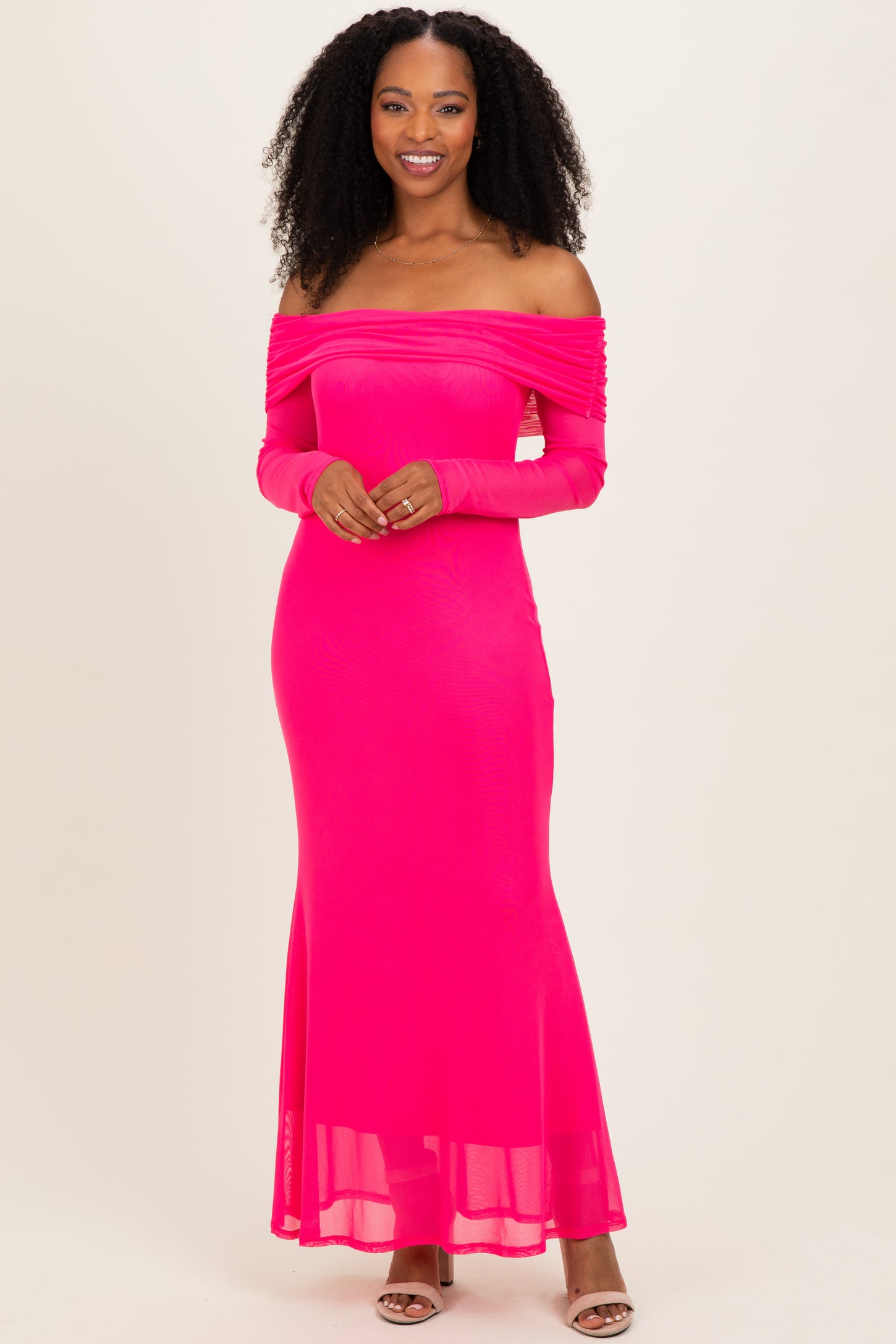 woman wearing a hot pink off-the-shoulder maxi dress with long sleeves and ruching details