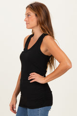 woman wearing a black sleeveless ruched tank top, styled with straight-leg jeans