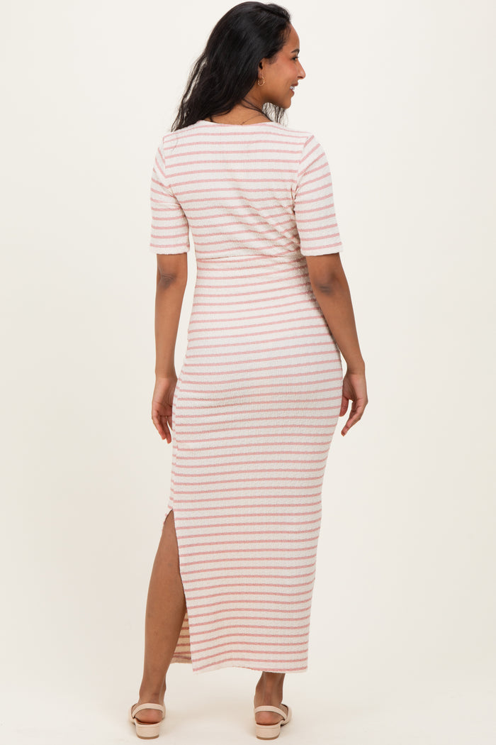 woman wearing a striped maternity maxi dress with a side slit and short sleeves, showing off her baby bump