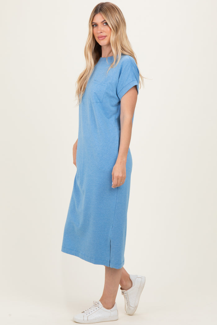 woman wearing a blue midi t-shirt dress with a pocket and side slit, standing against a light background