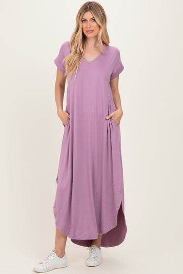 woman wearing a lavender short sleeve maxi dress with pockets and side slits, paired with white sneakers