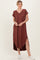 woman wearing a rust-colored short sleeve maxi dress with a v-neck and side slits