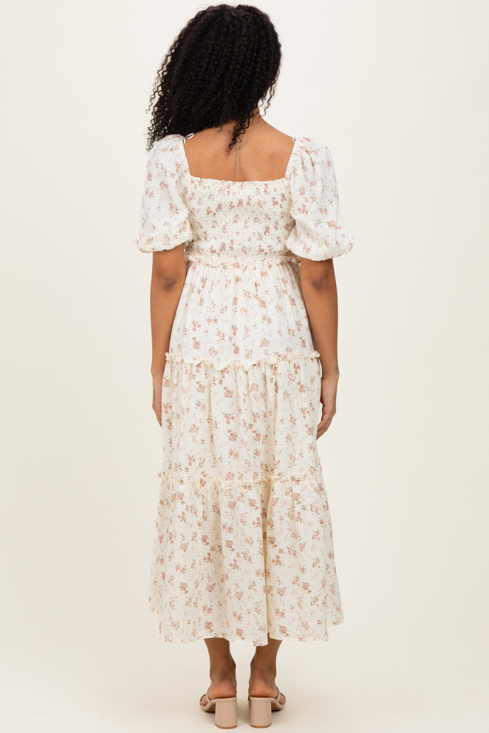 woman wearing a white floral maxi dress with puff sleeves and a smocked bodice, view from the back