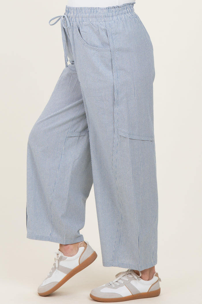 woman wearing light blue and white striped maternity wide-leg pants with drawstring waist and side pockets.