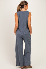 woman wearing a gray sleeveless maternity top with back seam detail and matching wide-leg maternity pants with side buttons